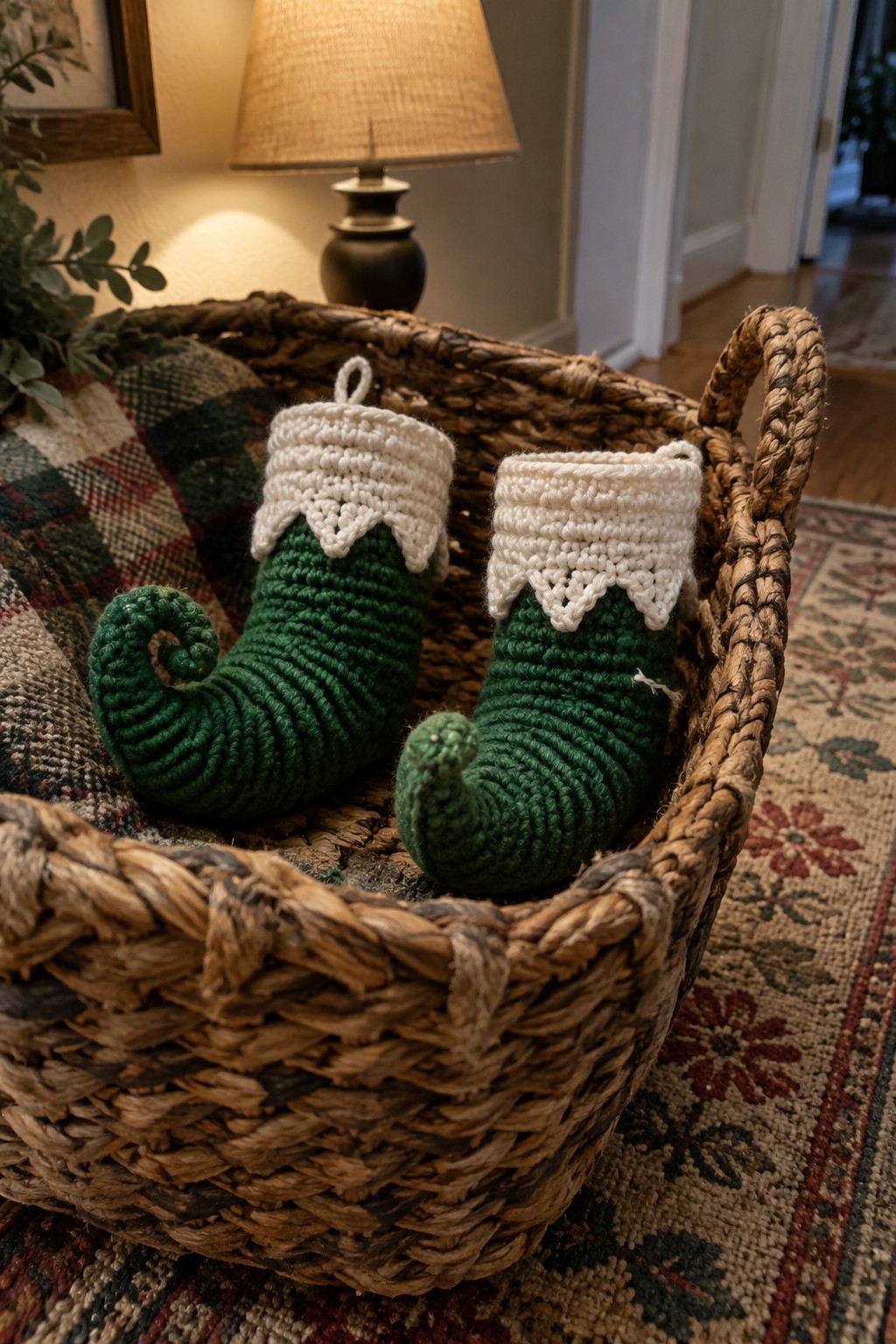 Two green crocheted elf stockings with white cuffs in woven basket