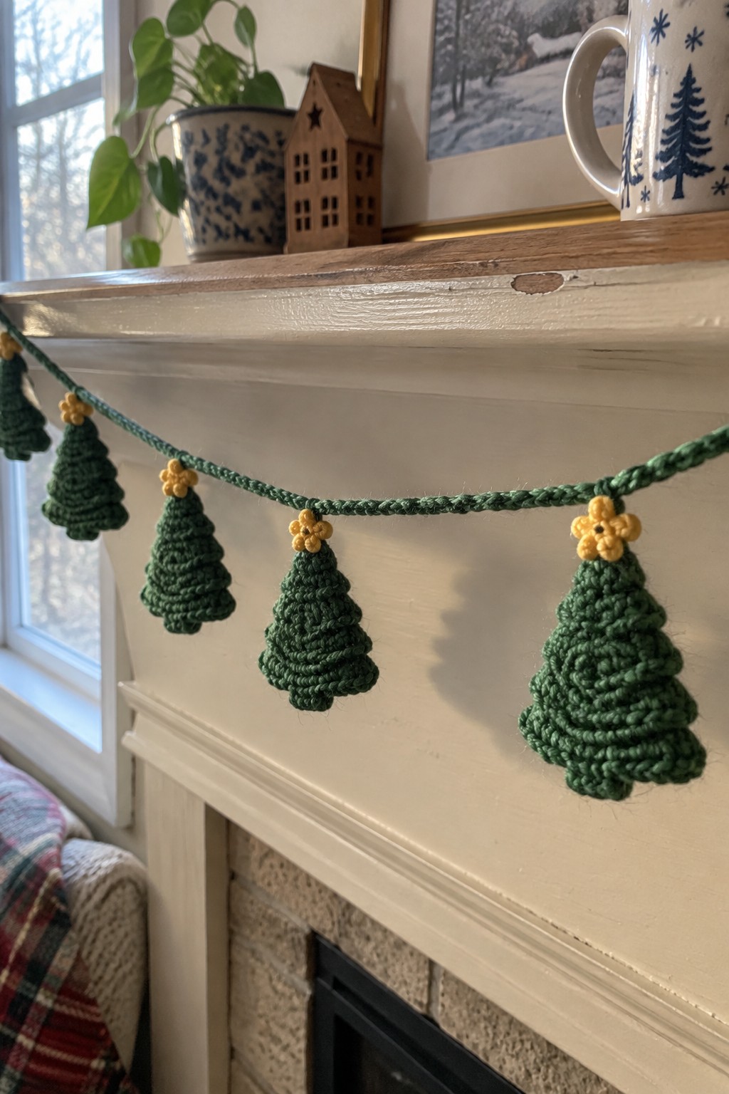 Crocheted green Christmas tree garland with yellow tops on white mantel